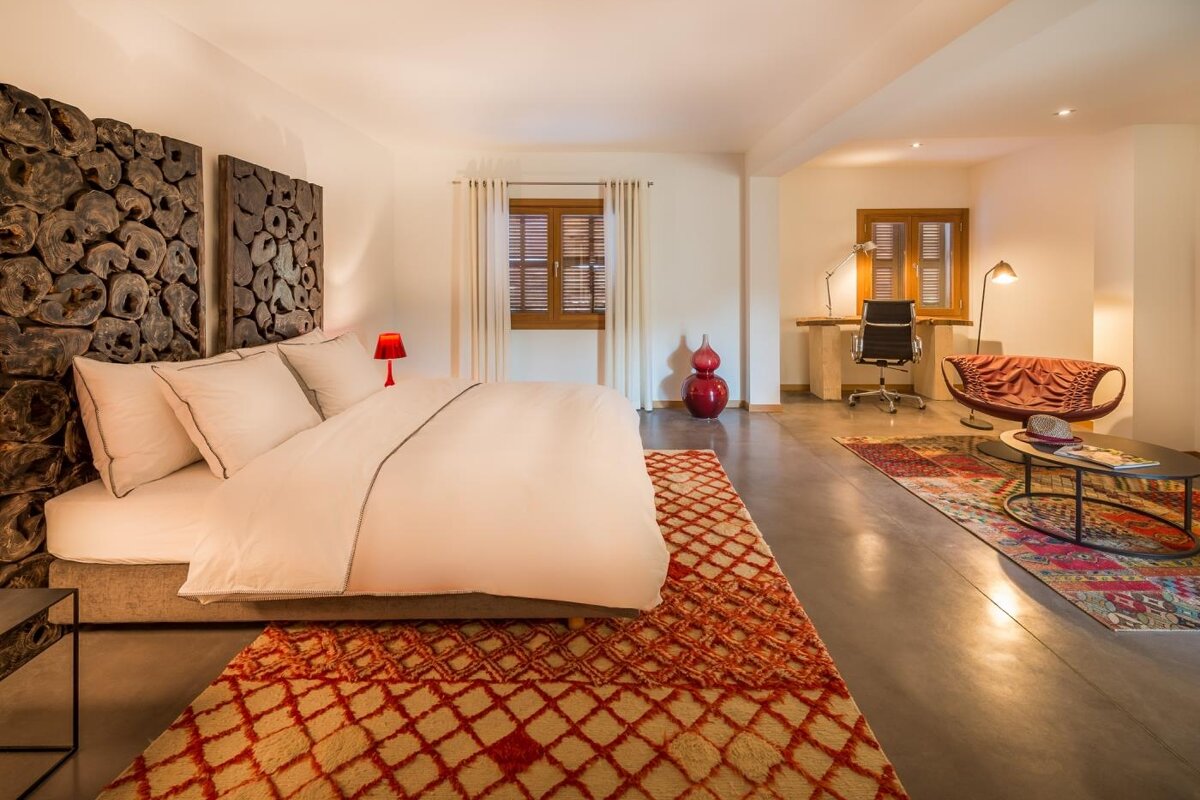 A bedroom with a large bed and a chair