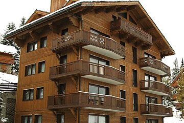 A large wooden building with many balconies and windows