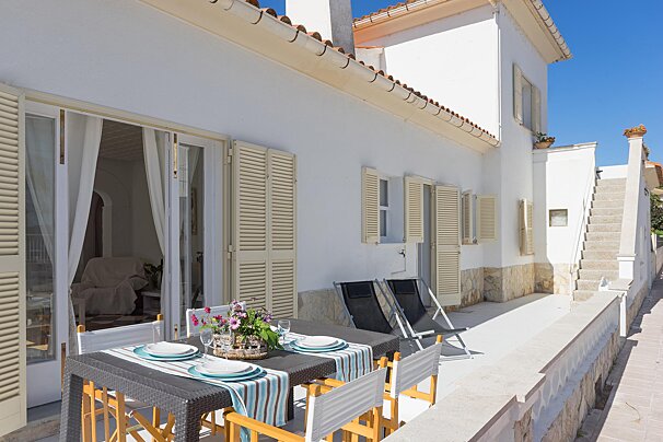 A patio with a table and chairs and plates on it