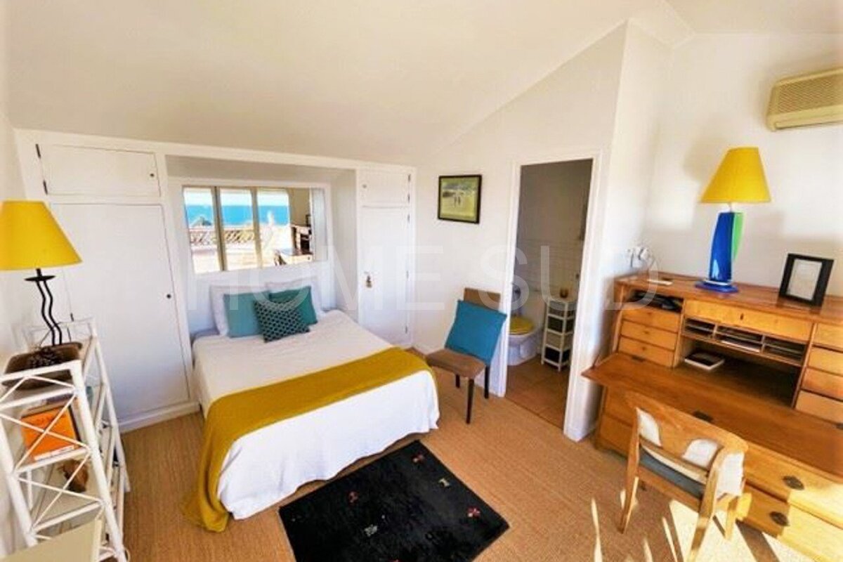 A bedroom with a bed , desk , chair and dresser