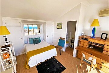 A bedroom with a bed , desk , chair and dresser