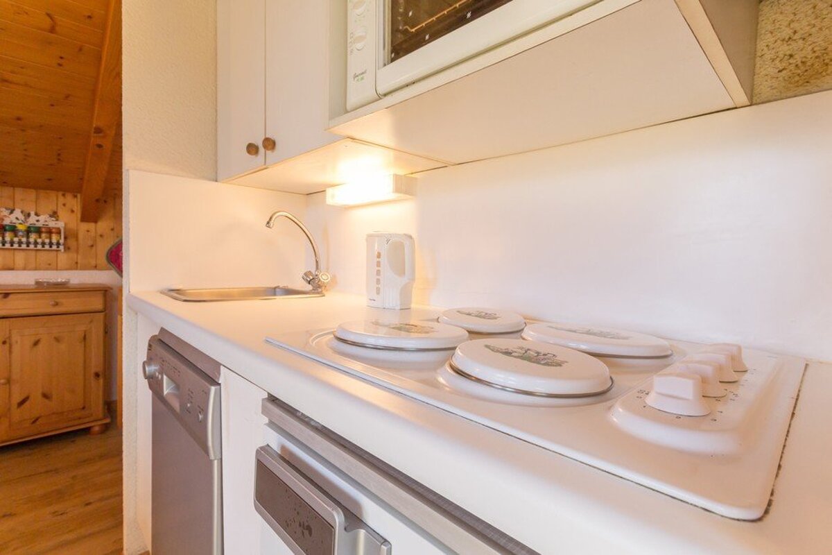 A kitchen with a stove top oven and a microwave