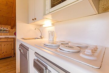 A kitchen with a stove top oven and a microwave