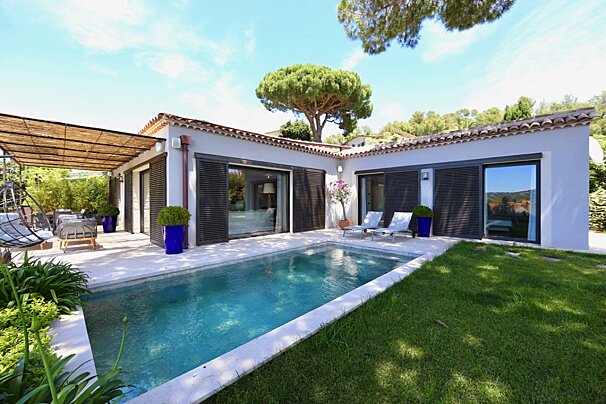 A house with a large swimming pool in front of it