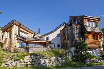 A large wooden house with a blue sky in the background