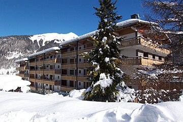 A snowy building with a mountain in the background