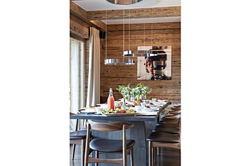 A dining room table with a bottle of orange juice on it