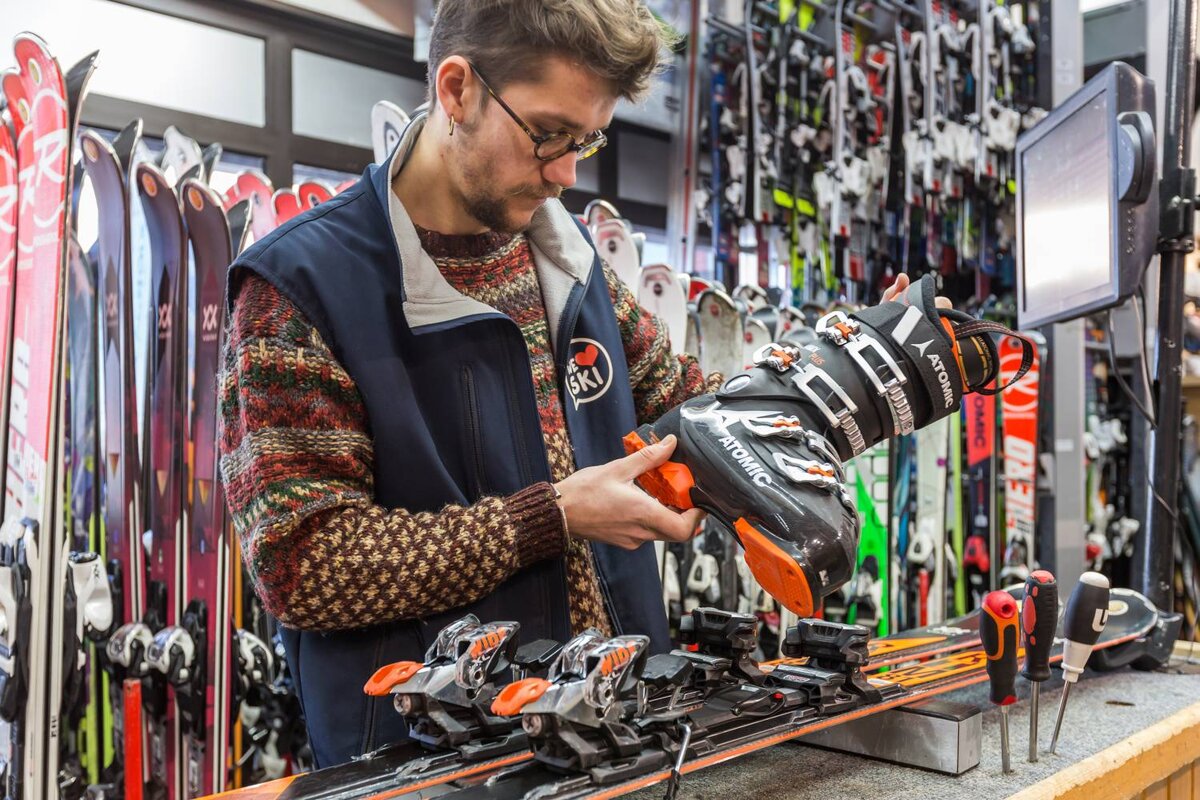 A man is working on a pair of atomic skis