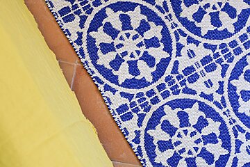 A blue and white rug is on a tiled floor