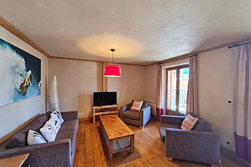 A living room with a couch a chair and a flat screen tv