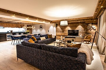 A living room with a blue couch and a flat screen tv