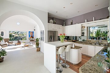 A kitchen with white cabinets and granite counter tops