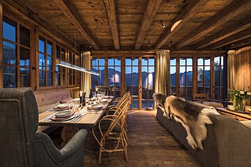 A dining room with a table and chairs and a couch