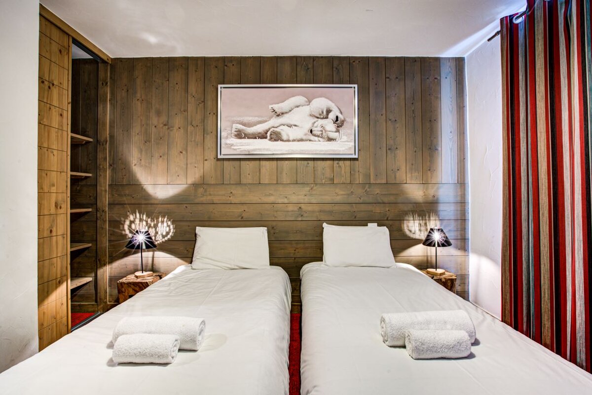 A bedroom with two beds and a picture of two polar bears on the wall