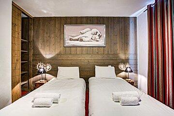 A bedroom with two beds and a picture of two polar bears on the wall