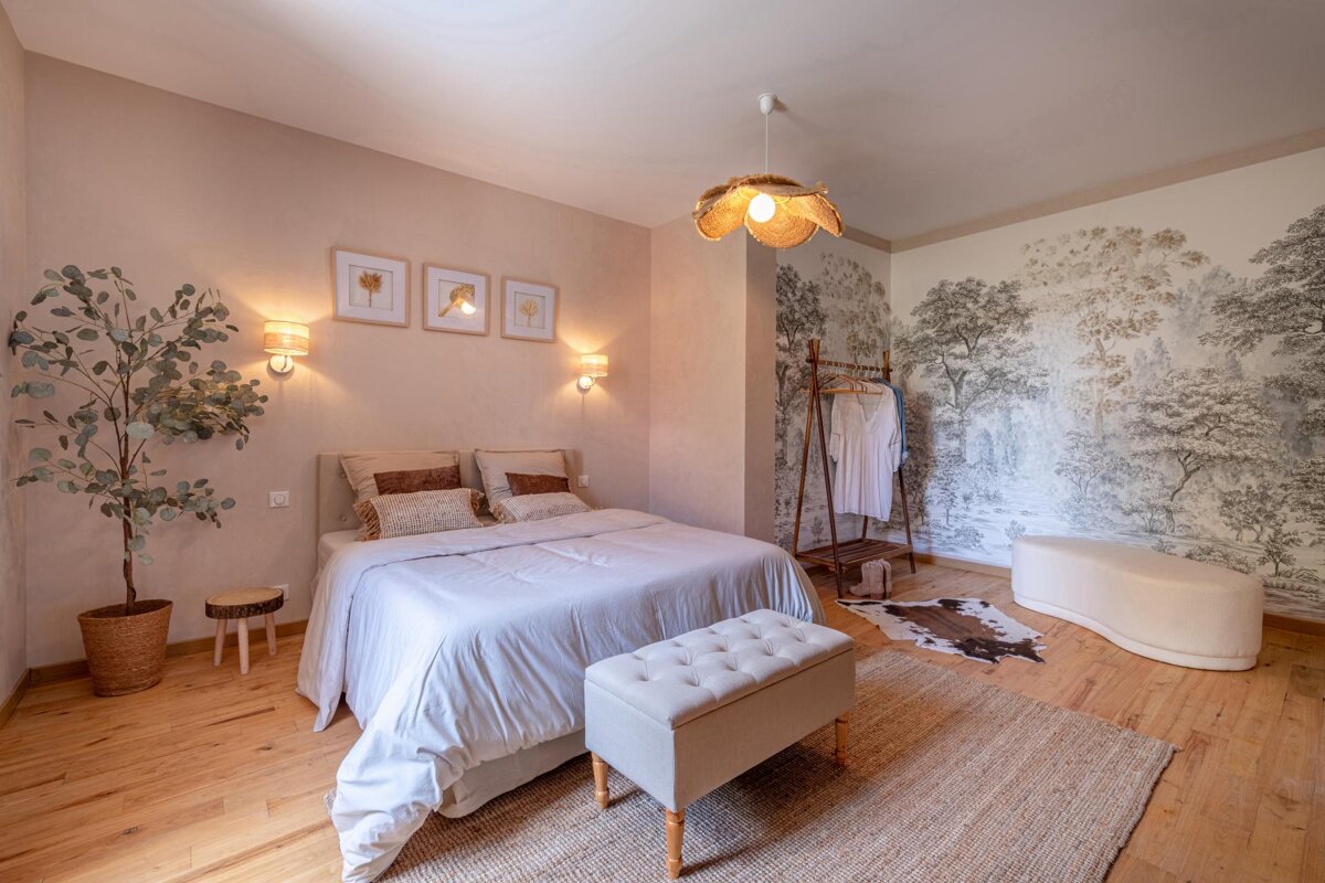 A bedroom with a large bed and a painting on the wall