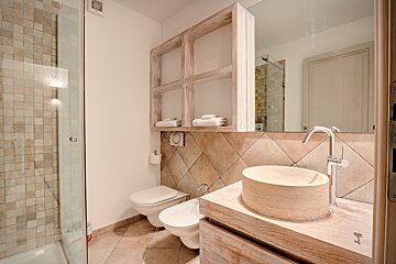 A bathroom with a toilet a sink and a mirror