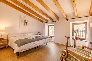 A bedroom with a large bed and a chair