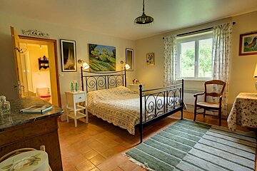 A bedroom with a wrought iron bed and a rug
