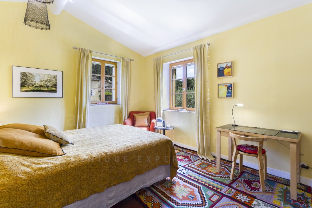 A bedroom with a bed and a desk that says antique expert