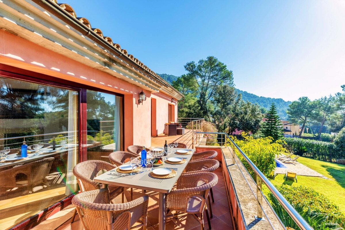A balcony with a table and chairs set for a meal