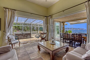 A living room with a table and chairs and a view of the ocean