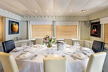 A dining room table with a vase of flowers on it