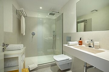 A bathroom with a toilet a sink and a shower