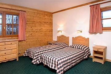 A bedroom with two beds and a dresser