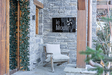 A stone wall with a sign that says le moulin