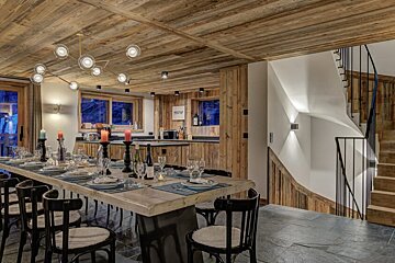 A dining room table with plates and candles on it
