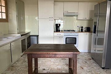 A kitchen with white cabinets and a stainless steel refrigerator
