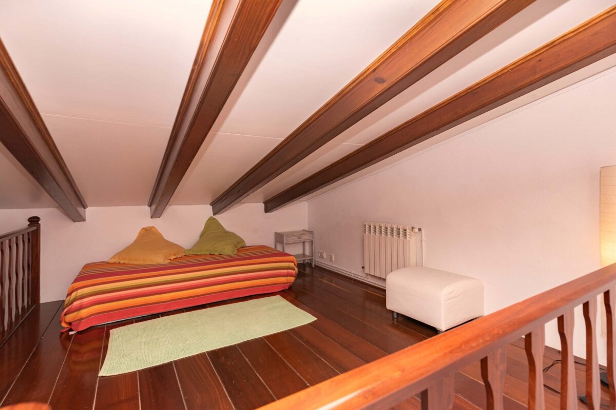 A bedroom with a bed and a radiator on the wall
