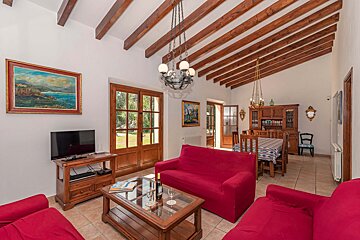 A living room with a red couch and a flat screen tv