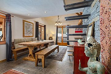 A dining room with a wooden table and benches