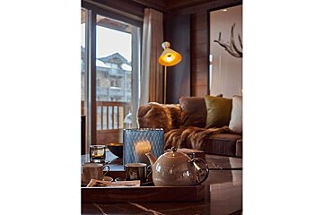 A living room with a couch and a teapot on the table