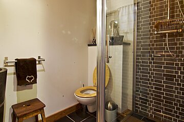 A bathroom with a toilet and a towel with a heart on it