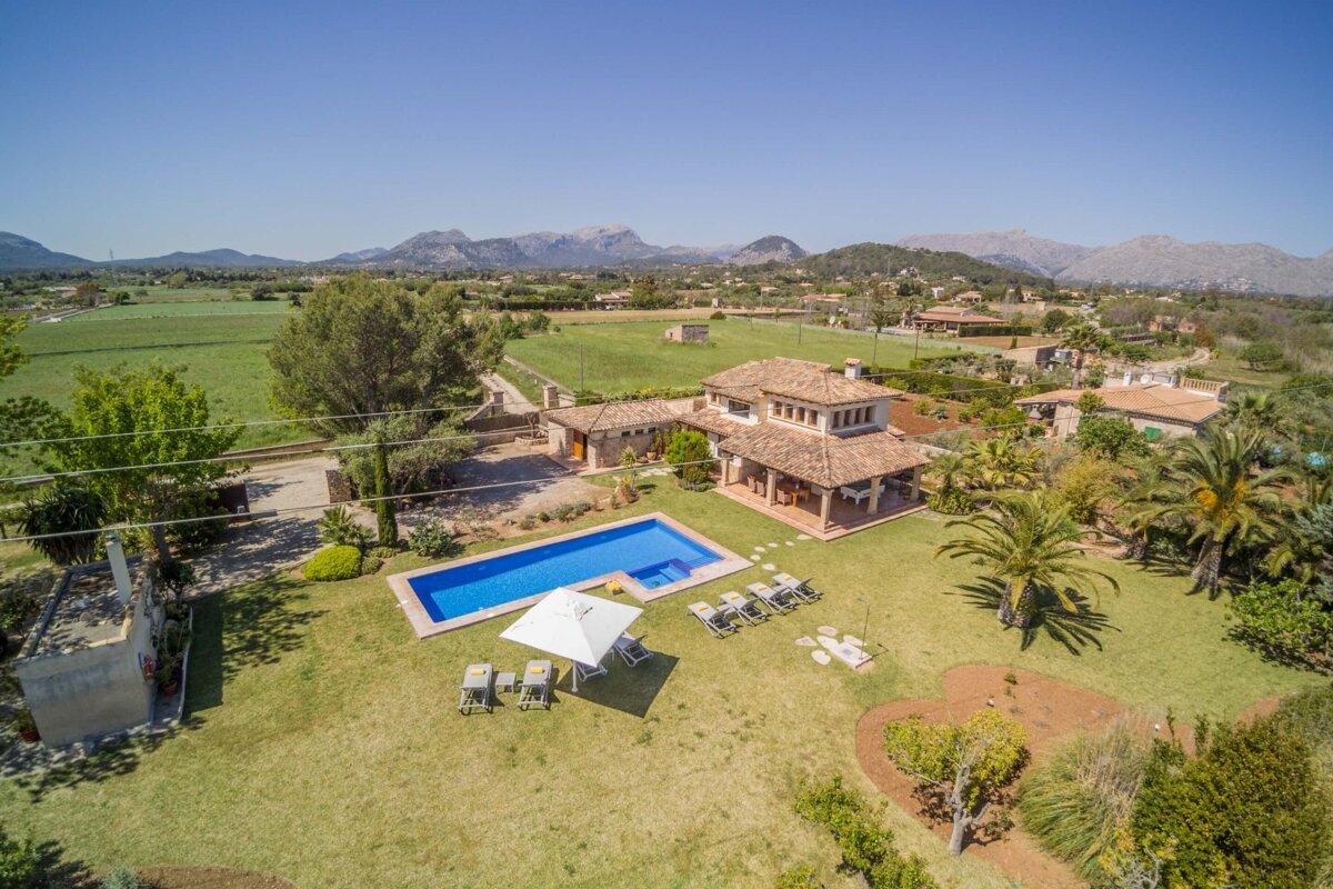 An aerial view of a house with a large swimming pool