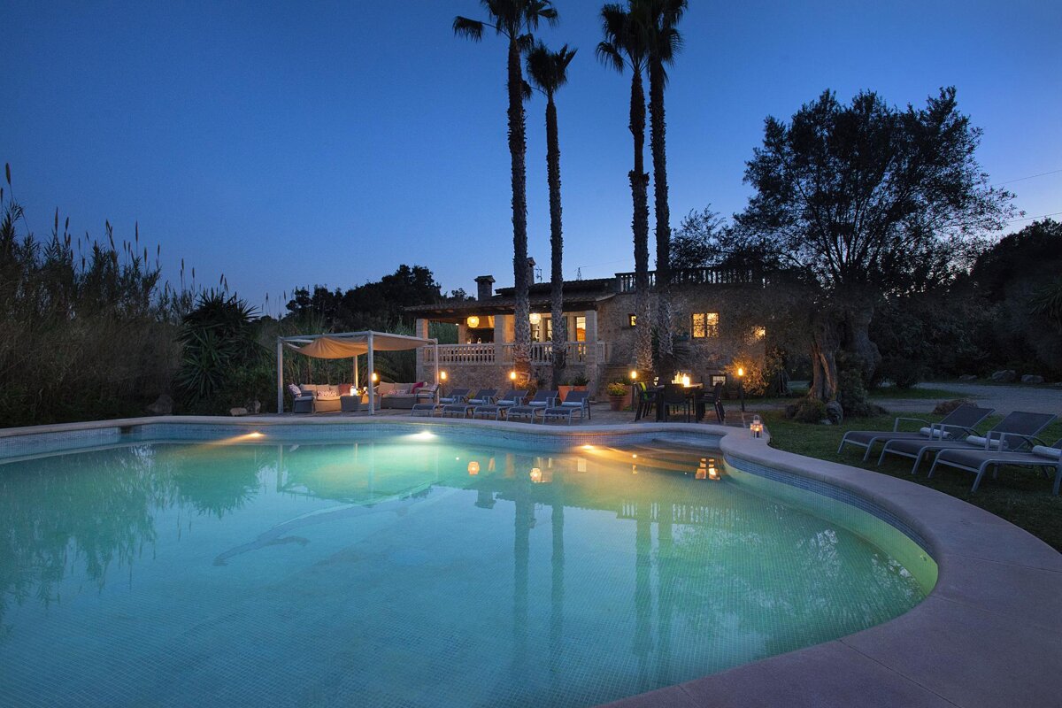 A large house with a swimming pool in front of it