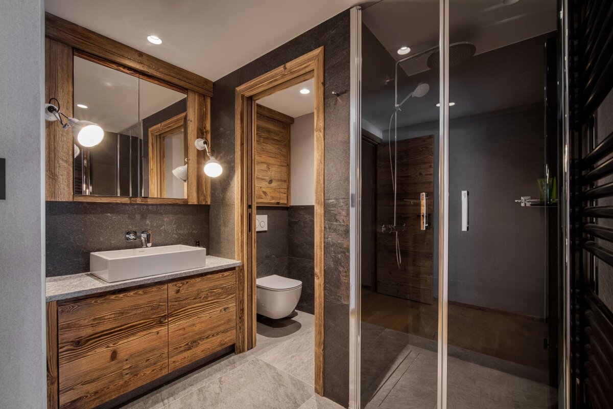 A bedroom with a bed and a window with mountains in the background