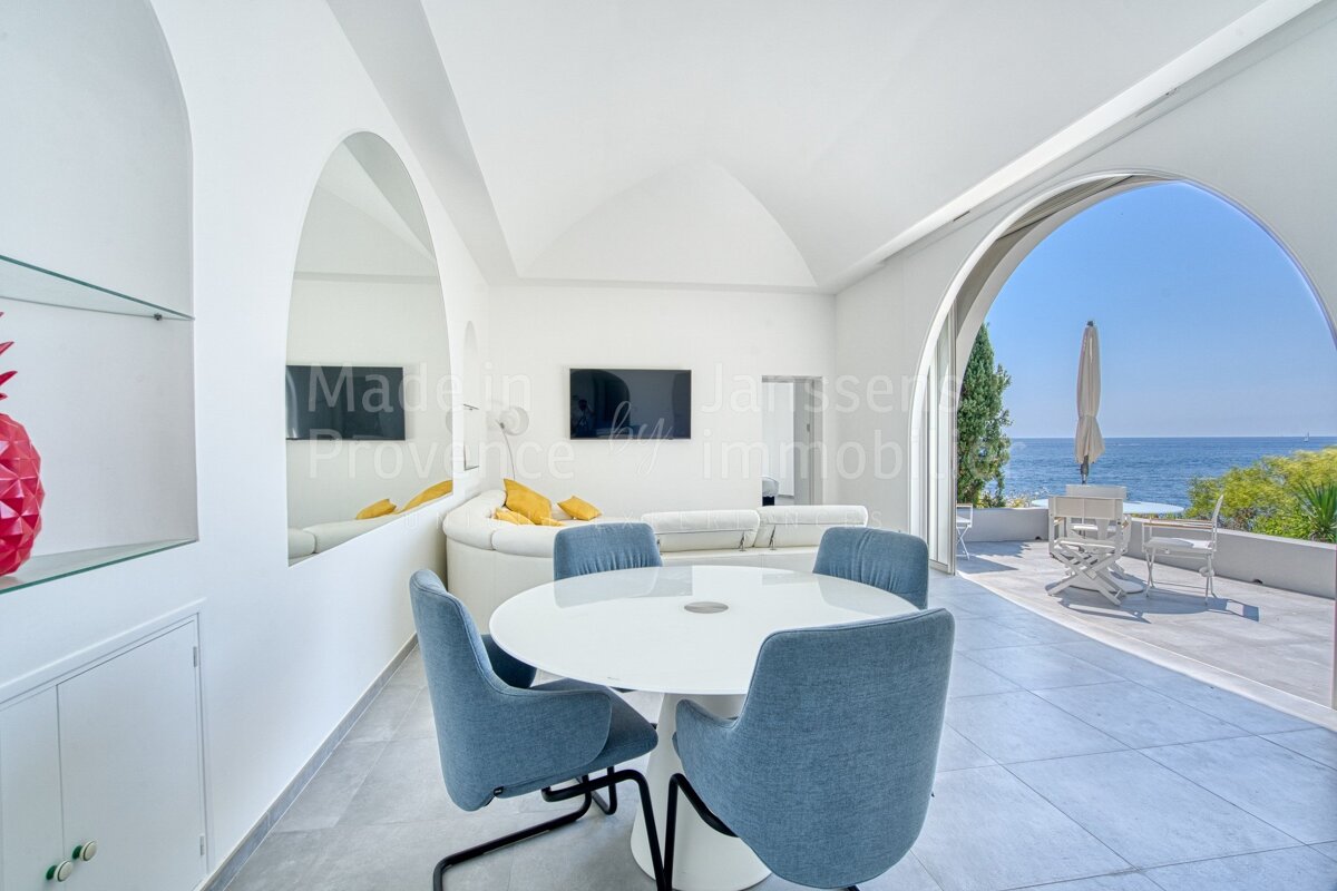 A living room with a table and chairs and the word immobilier on the wall