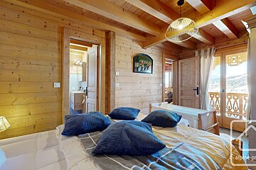 A bedroom with a painting on the wall above the bed
