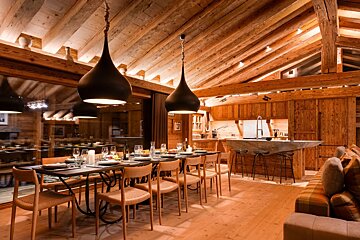 A dining room with a long table and chairs