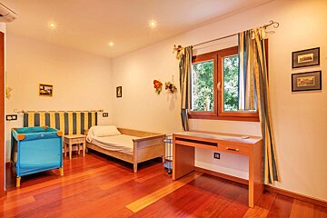 A bedroom with a single bed and a desk