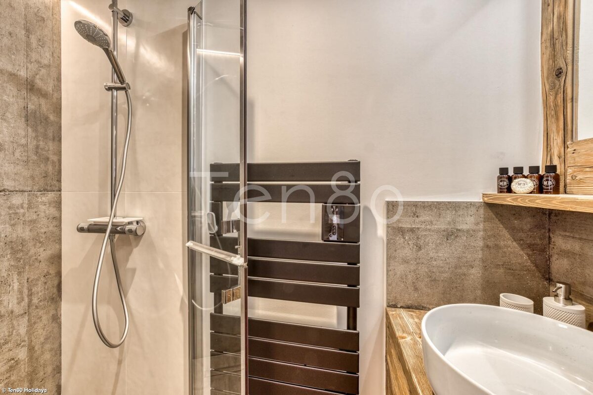 A bathroom with a towel rack and a sink and a sign that says ten80