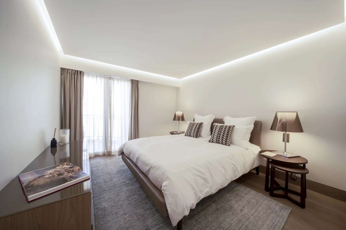 A bedroom with a bed and a book on the dresser