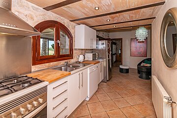 A kitchen with white cabinets and a stainless steel refrigerator