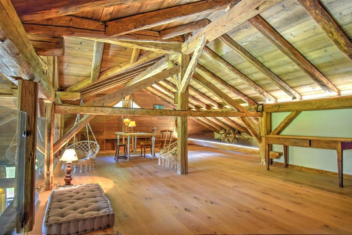 An attic with wooden beams and a table and chairs