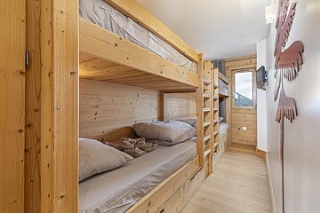 A wooden bunk bed in a room with a sign on the wall