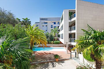 A large white building with a swimming pool in front of it